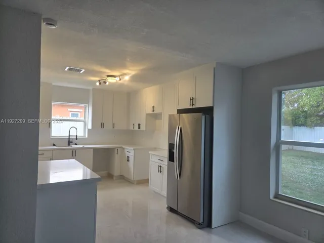 a large kitchen with cabinets and stainless steel appliances