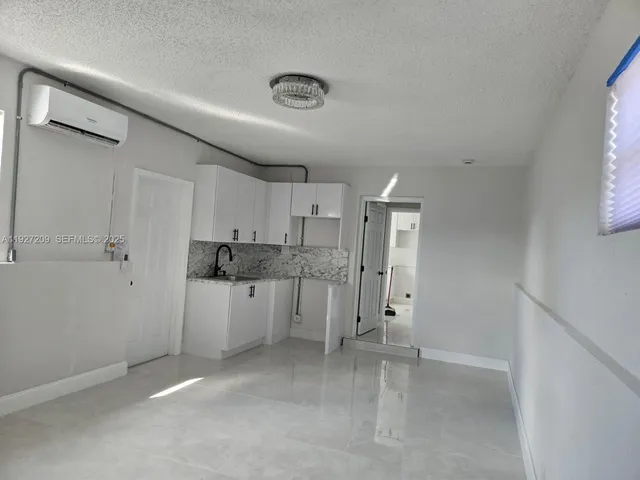 a view of a kitchen with white cabinets and white appliances