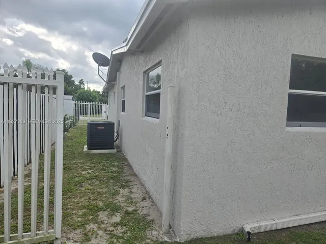 a view of a house with a yard and potted plants