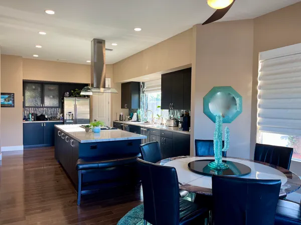 a kitchen with stainless steel appliances a sink stove and wooden floor