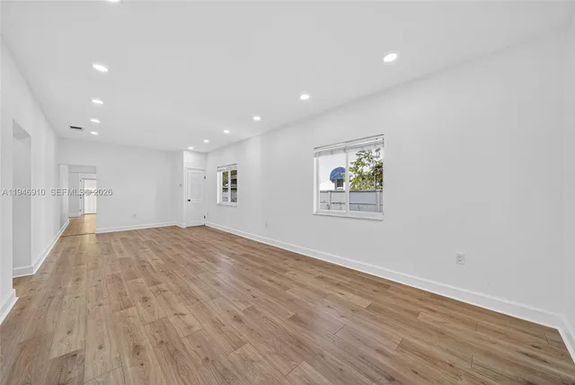 a view of empty room with wooden floor