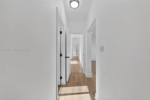 a view of a hallway with wooden floor and glass door