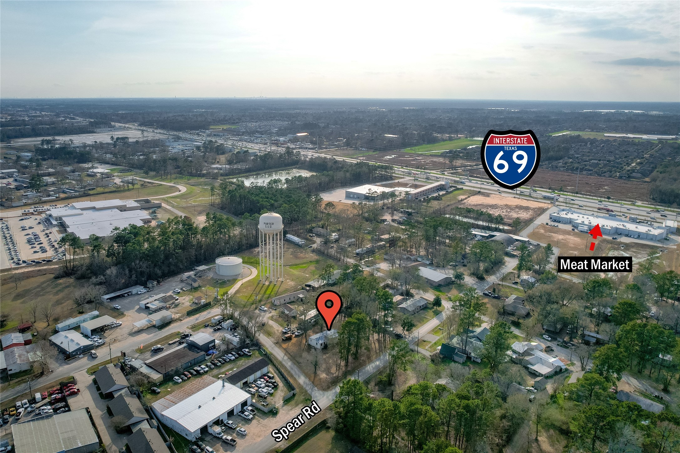 22094 Spear Road Porter, TX 77365 - Photo 42 of 45 This aerial photo showcases a residential area near Spear Rd, with easy access to Interstate 69. The neighborhood features lush greenery and a meat market for convenient shopping. Ideal for those seeking a blend of suburban living with quick highway access.