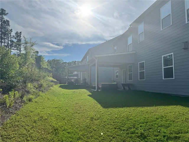 a view of a backyard with plants and large trees