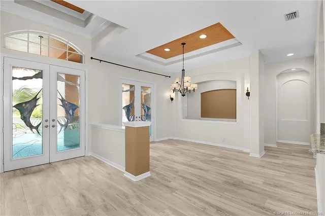 a view of a room with wooden floor and chandelier