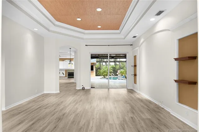 a living room with stainless steel appliances wooden floor and a window