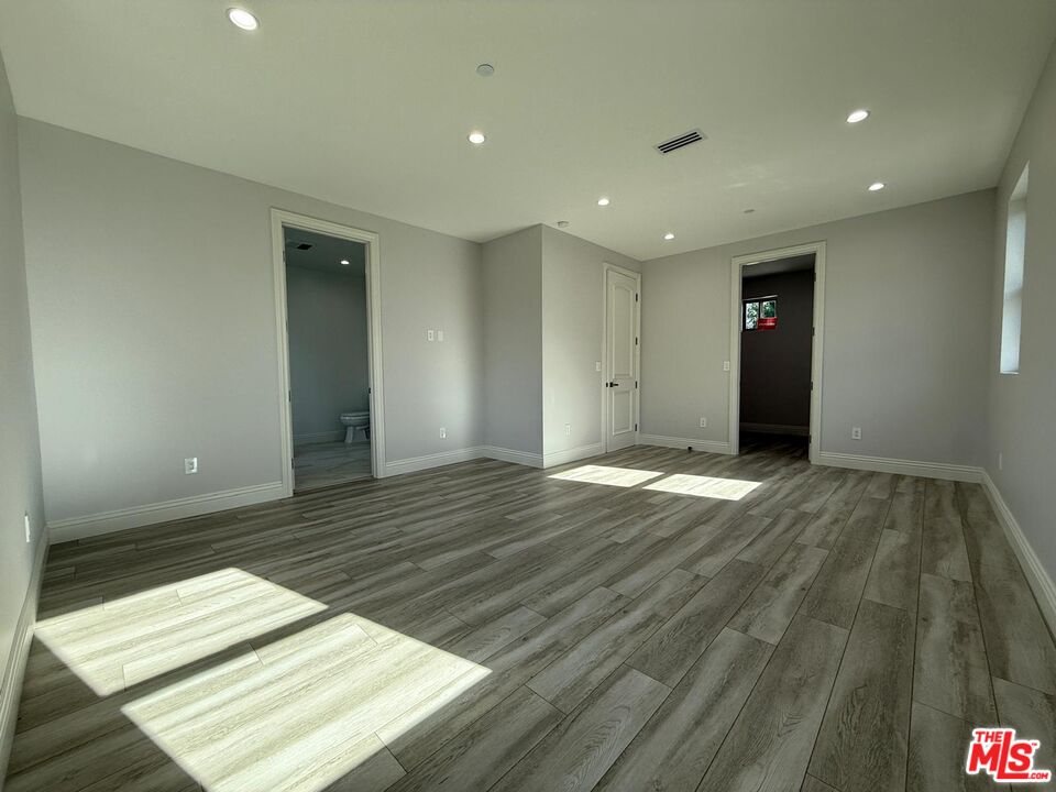 6717 Sunnyslope Avenue Van Nuys, CA 91401 - Photo 18 of 43 an empty room with wooden floor and natural light
