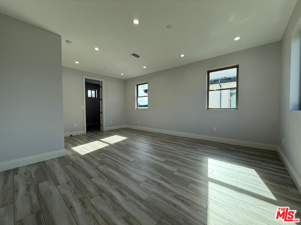 6717 Sunnyslope Avenue Van Nuys, CA 91401 - Photo 19 of 43 an empty room with wooden floor and windows