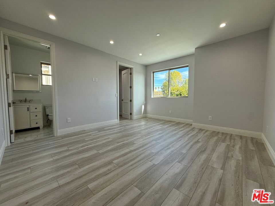 6717 Sunnyslope Avenue Van Nuys, CA 91401 - Photo 26 of 43 an empty room with wooden floor and windows