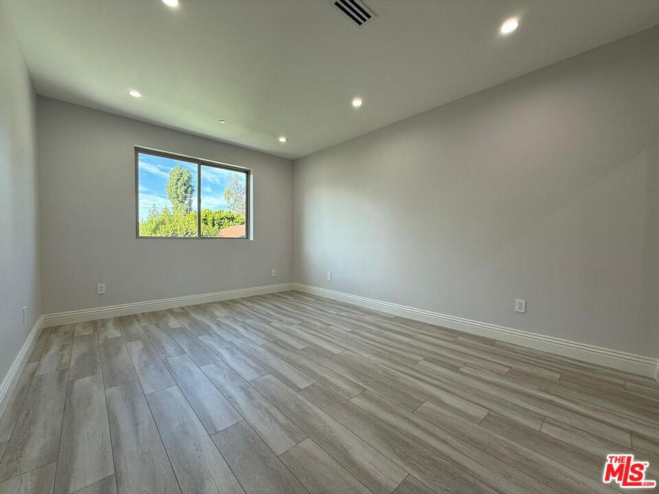 6717 Sunnyslope Avenue Van Nuys, CA 91401 - Photo 33 of 43 an empty room with wooden floor and windows