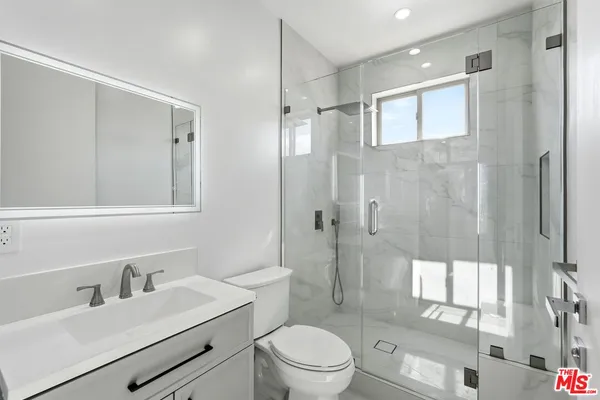 a bathroom with a sink a toilet and shower