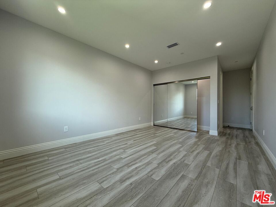 6717 Sunnyslope Avenue Van Nuys, CA 91401 - Photo 34 of 43 an empty room with wooden floor and windows