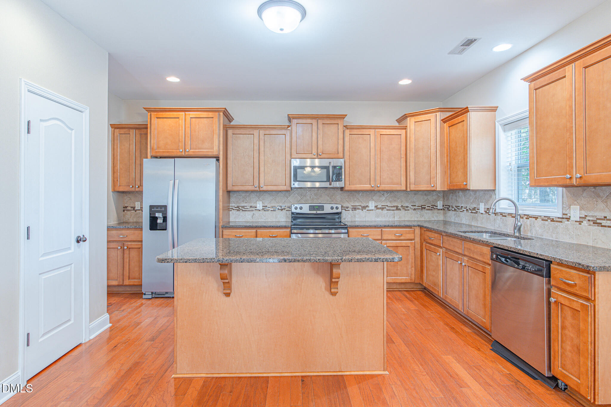 403 Rolling Pines Drive Spring Lake, NC 28390 - Photo 13 of 56 a kitchen with stainless steel appliances granite countertop a refrigerator a sink dishwasher a stove and white countertops with wooden floor
