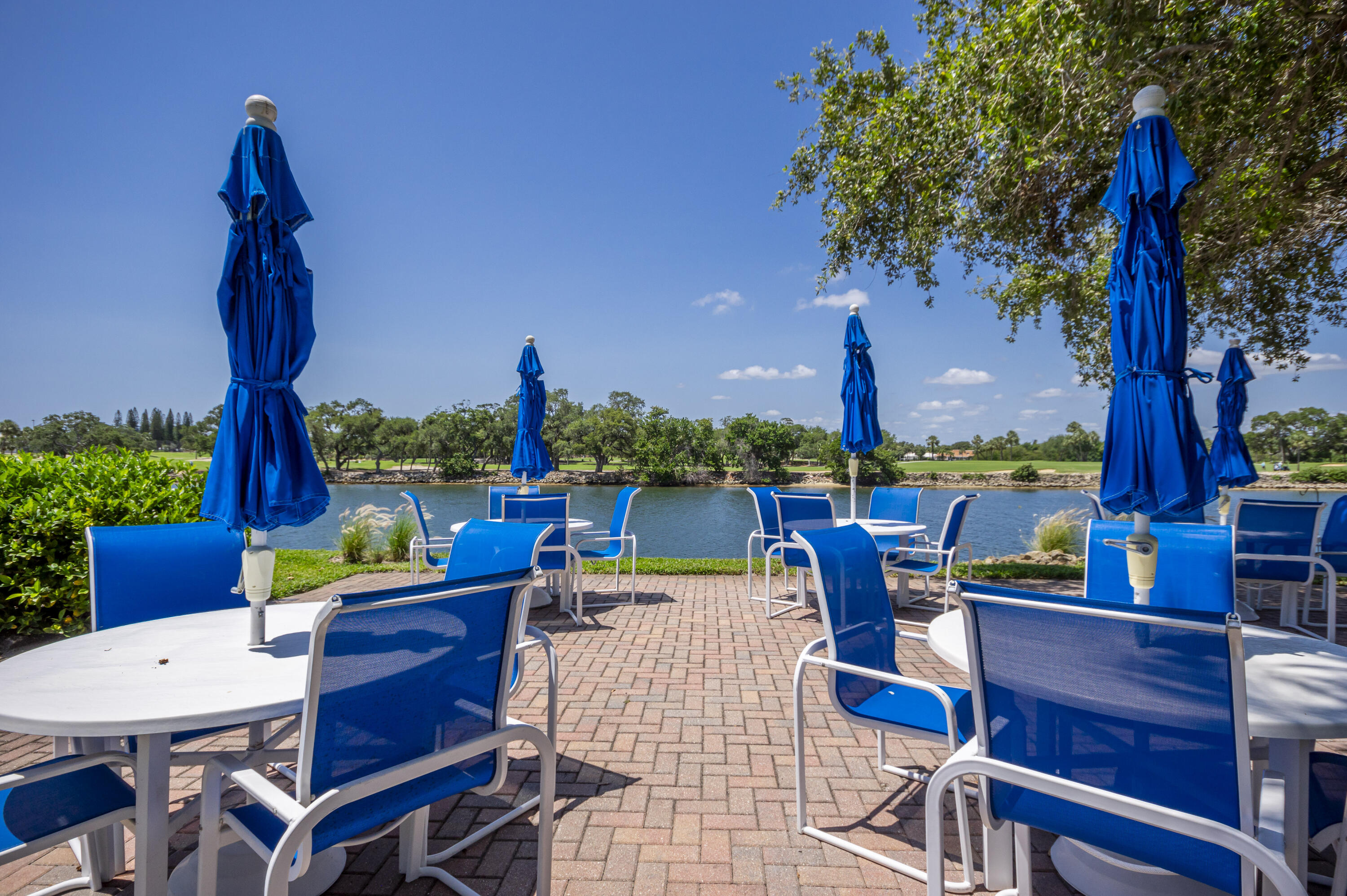 336 Golfview Road, Unit 518 North Palm Beach, FL 33408 - Photo 29 of 31 a view of a patio with table and chairs potted plants and a palm tree