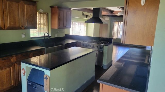 a kitchen with stainless steel appliances granite countertop wooden cabinets a stove and a sink