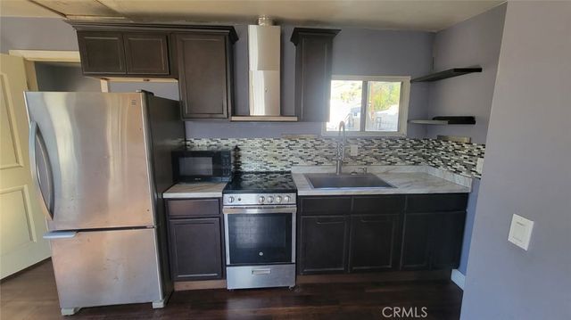 a kitchen with a refrigerator sink and cabinets