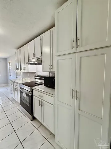 a kitchen with white cabinets and white appliances