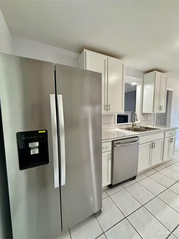 a kitchen with a refrigerator sink and cabinets