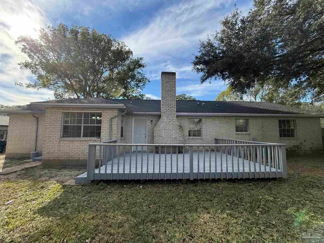 a view of a house with wooden deck and furniture