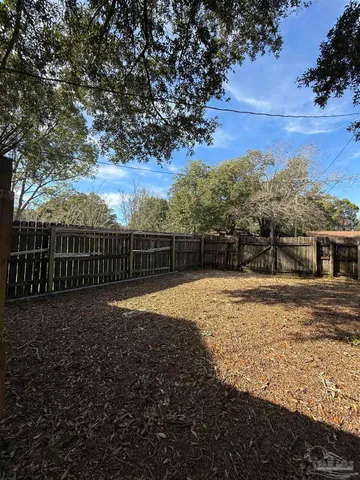 a view of a yard with wooden fence