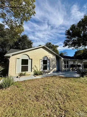 a white house with a large tree in front of it