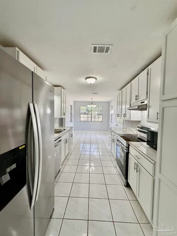 a kitchen with stainless steel appliances a refrigerator sink and cabinets