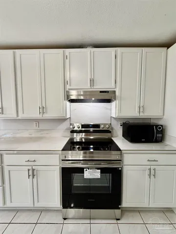 a kitchen with white cabinets and appliances
