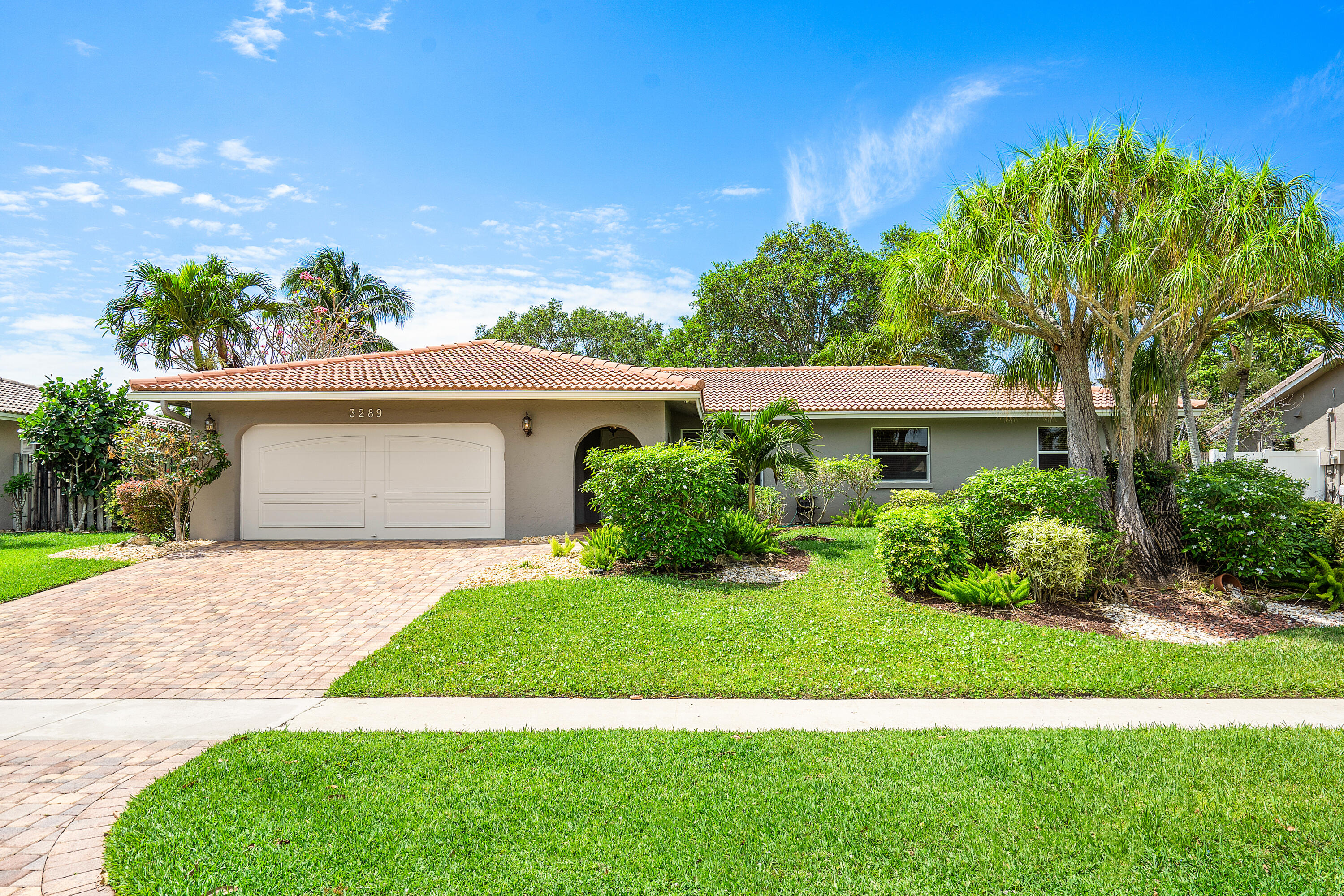 3289 Northwest 26th Avenue Boca Raton, FL 33434 - Photo 1 of 10 a front view of a house with a yard and potted plants