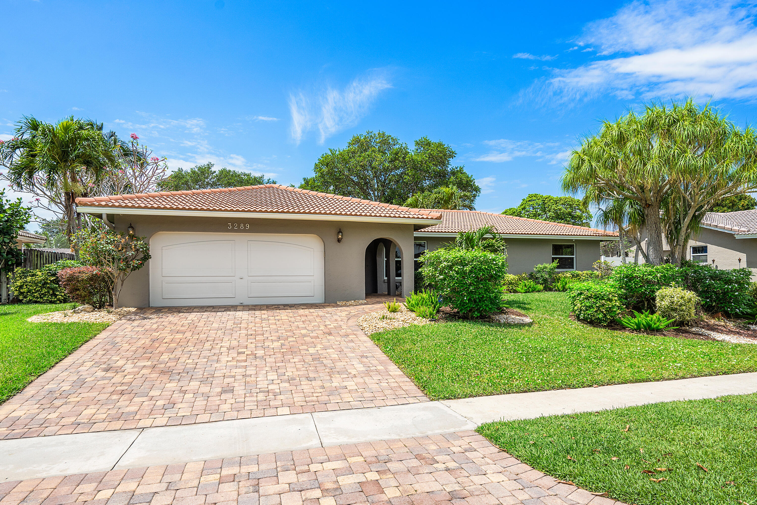 3289 Northwest 26th Avenue Boca Raton, FL 33434 - Photo 2 of 10 a front view of a house with a yard