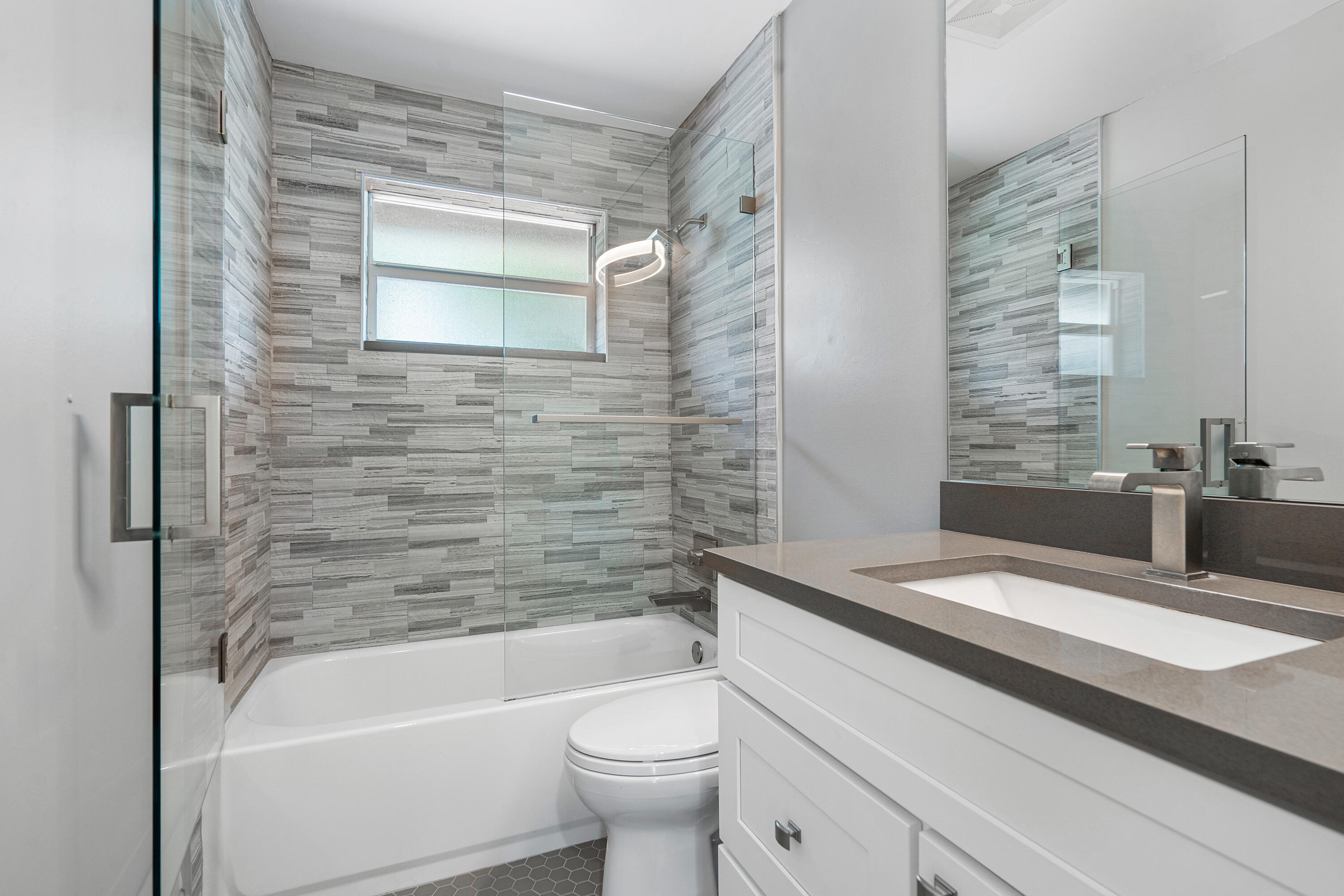 3289 Northwest 26th Avenue Boca Raton, FL 33434 - Photo 10 of 10 a bathroom with a granite countertop sink a toilet and bathtub