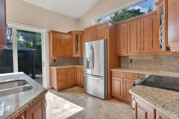 a kitchen with stainless steel appliances granite countertop a refrigerator a sink and a stove