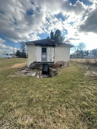a backyard of a house with table and chairs