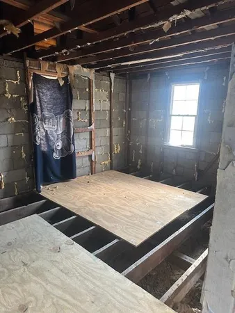 a bed sitting in a bedroom next to a window