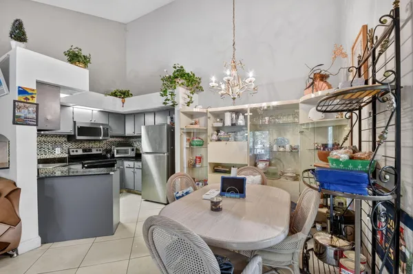 a kitchen with stainless steel appliances a dining table chairs and chandelier