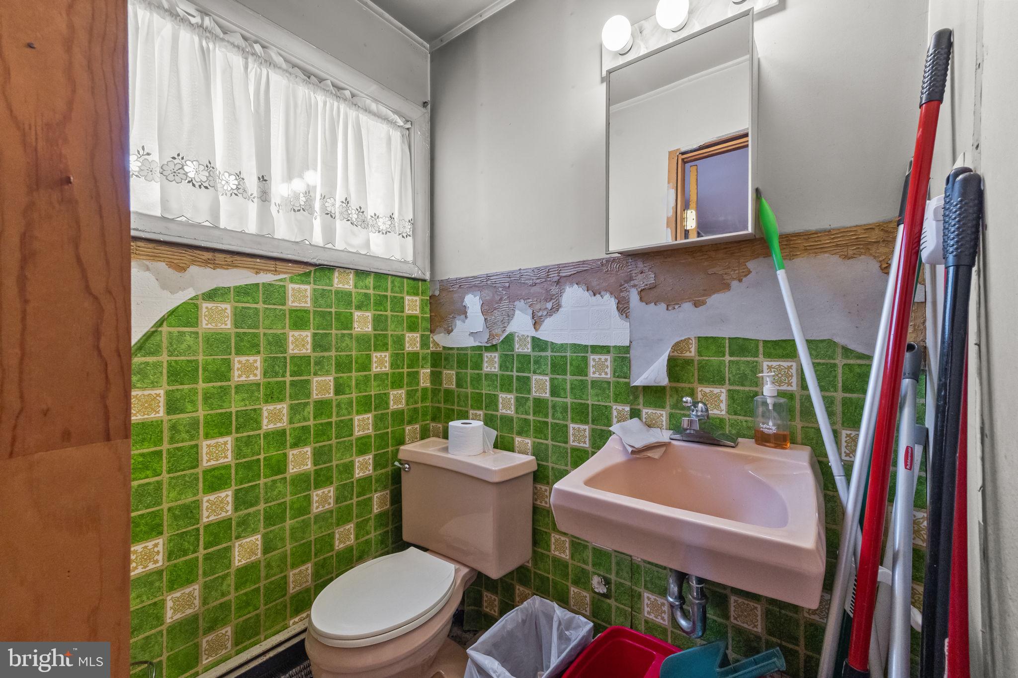 65 Silverspruce Road Levittown, PA 19056 - Photo 17 of 32 a bathroom with a toilet a sink and a shower curtain