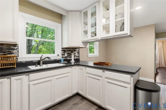 a kitchen with stainless steel appliances granite countertop white cabinets sink and window