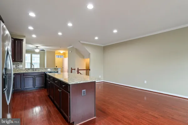 a kitchen with stainless steel appliances granite countertop a stove a sink a refrigerator and a island