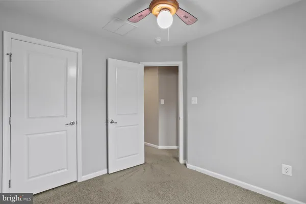 an empty room with a chandelier fan