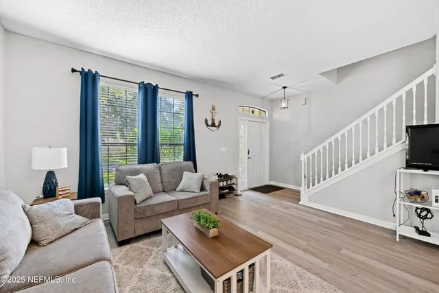 a living room with furniture a chandelier and a window