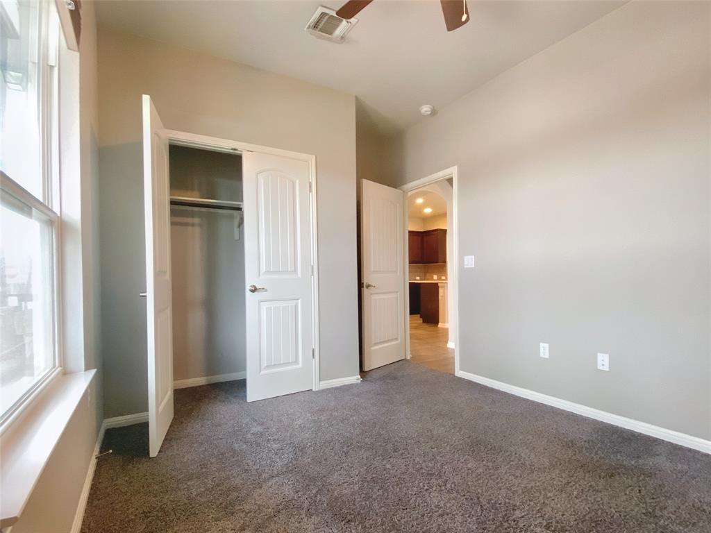 8901 Panhandle Drive Austin, TX 78747 - Photo 14 of 21 Neutral tone wall paint, vaulted ceiling, and grey carpet flooring