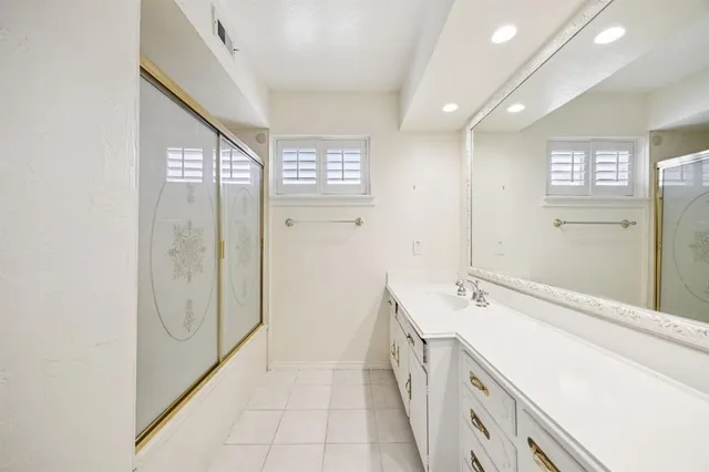 a bathroom with a sink a mirror and a shower