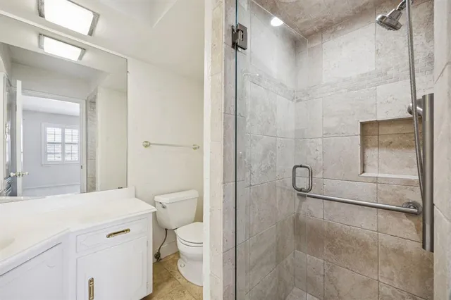 a bathroom with a granite countertop shower a toilet and a sink