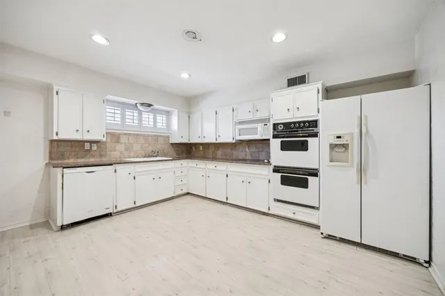 a kitchen with granite countertop white cabinets and white appliances