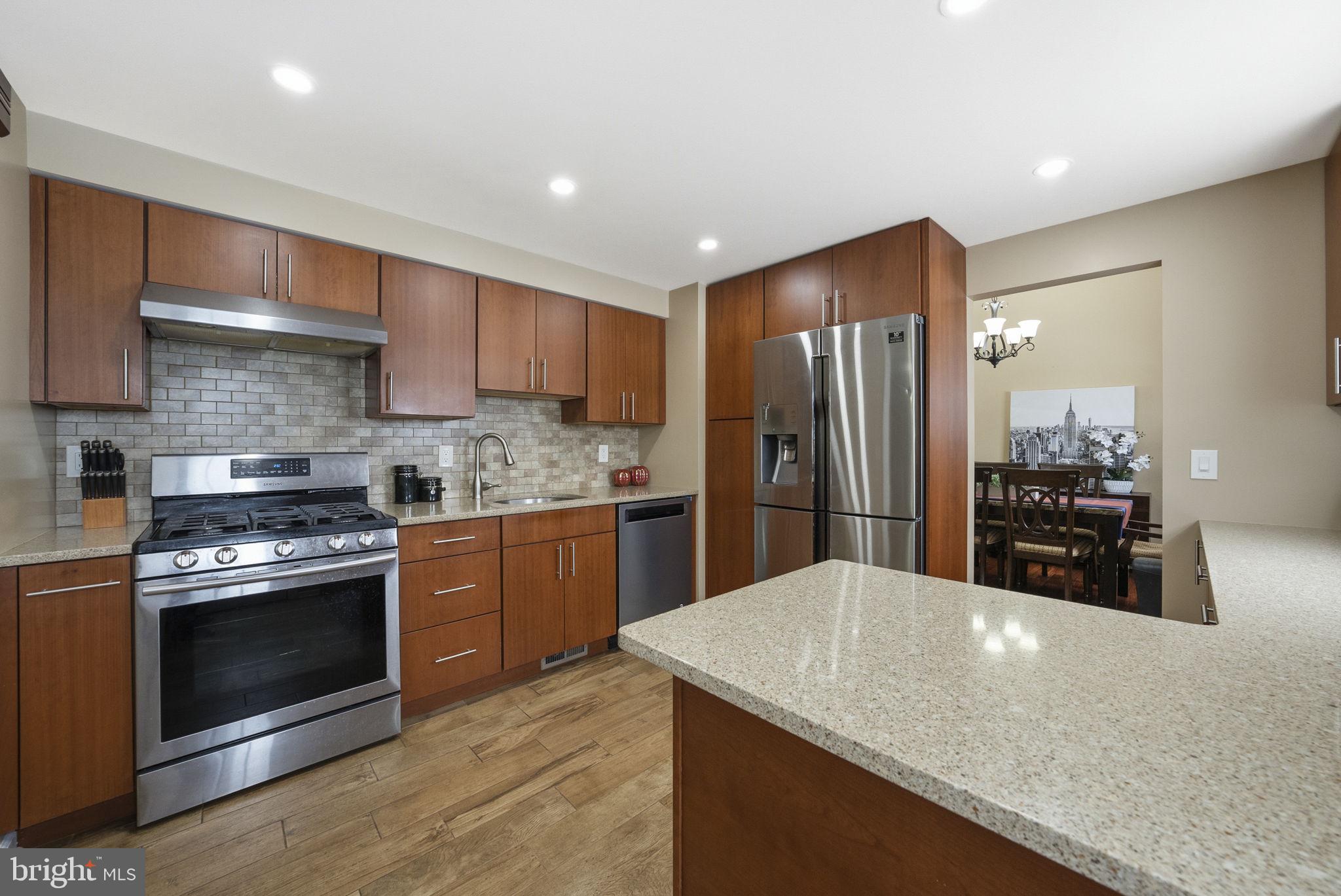 10 Magee Road Edison, NJ 08817 - Photo 12 of 45 a kitchen with stainless steel appliances kitchen island granite countertop a stove a sink and a refrigerator