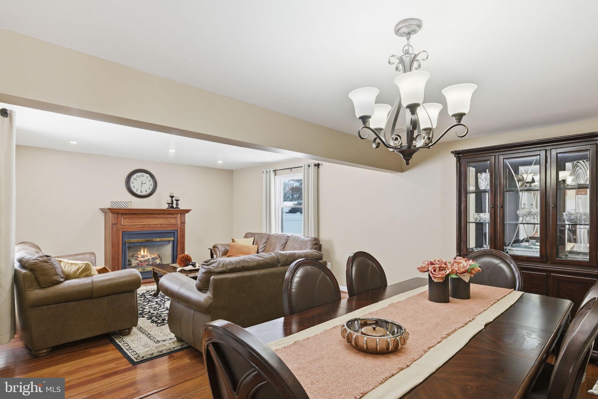 10 Magee Road Edison, NJ 08817 - Photo 5 of 45 a living room with furniture a chandelier and a fireplace
