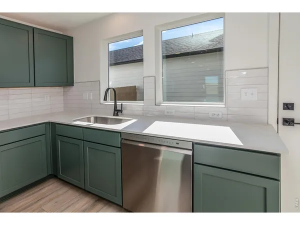 a kitchen with stainless steel appliances a stove a sink and a refrigerator