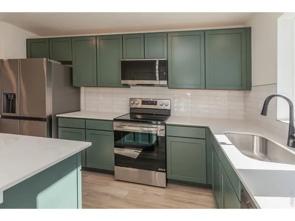 a kitchen with kitchen island a stove and a sink