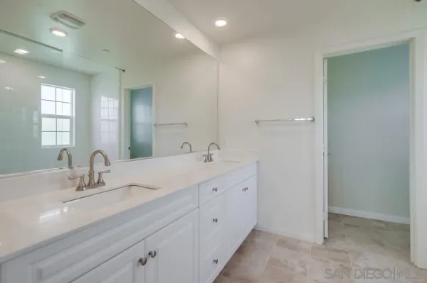 a bathroom with double sink and a mirror