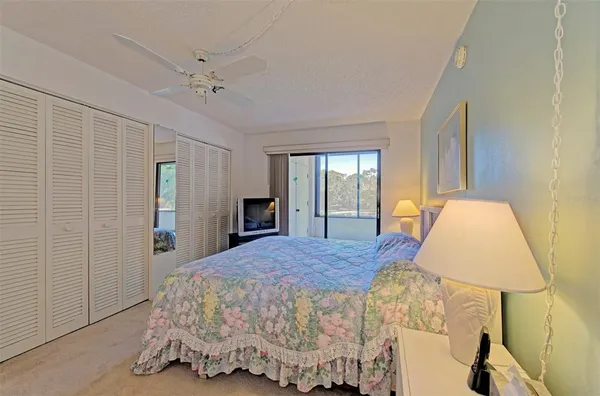 a spacious bedroom with a bed and a lamp