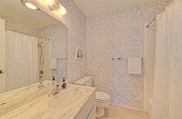 a bedroom with a bed and a potted plant on dresser